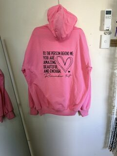pink zipper hoodie with black writing on the back